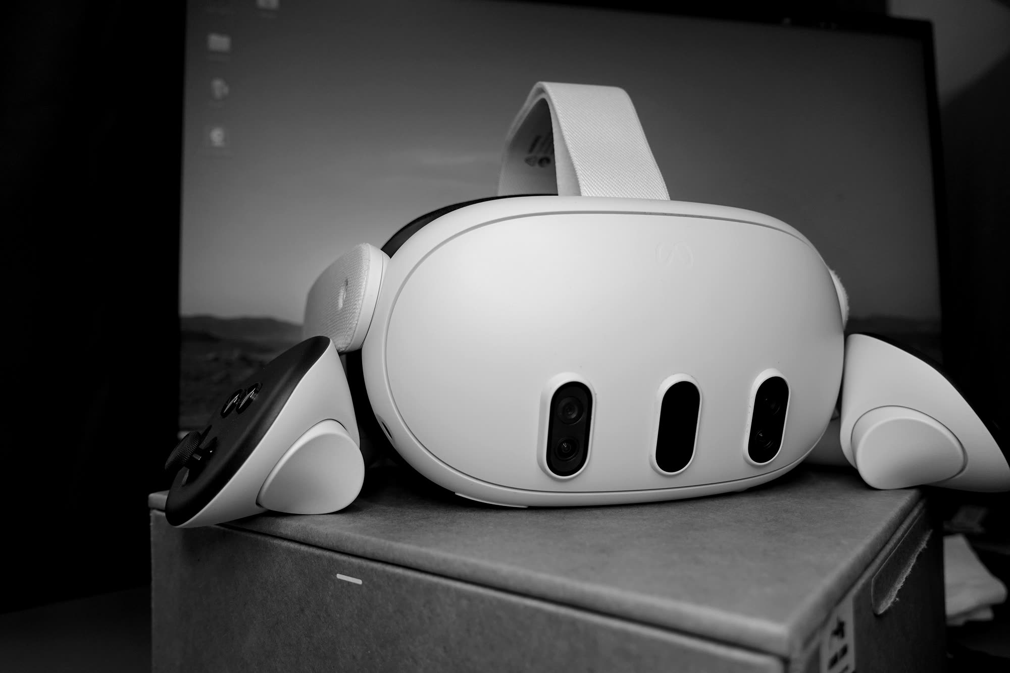 A Meta Quest 3 headset and one of its controllers on a table.